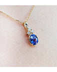 14K yellow gold pendant with oval tanzanite and three diamonds on a delicate chain.