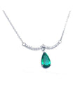 White gold necklace with a pear-shaped emerald dangling from a wavy bar with prong-set diamonds.