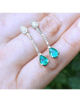 Pear-shaped Muzo Colombian emerald dangle earrings in 14K white gold with diamond accents.