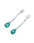Pear-shaped Muzo Colombian emerald dangle earrings in 14K white gold with diamond accents.