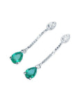 Pear-shaped Muzo Colombian emerald dangle earrings in 14K white gold with diamond accents.