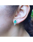 14K gold clip/post earring with a pear-shaped Colombian emerald and diamond accents on an ear.