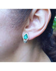 14K gold clip/post earring with a pear-shaped Colombian emerald and diamond accents on an ear.
