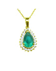 Teardrop emerald pendant with a natural diamond halo on a 14K gold chain.