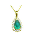 Teardrop emerald pendant with a natural diamond halo on a 14K gold chain.