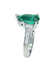 This teardrop emerald ring displays its left side profile from the top to down band view.