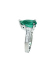 3.09 ct. pear-shaped deep green emerald ring with princess cut diamonds in 14K white gold.