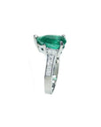 3.09 ct. pear-shaped deep green emerald ring with princess cut diamonds in 14K white gold.