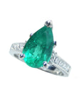 Ring with a natural Colombian teardrop emerald and diamond accents on a white background.