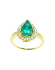 The top view of a ring with a teardrop emerald encircled by a halo diamond in 14k yellow gold.