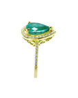 Side profile of a pear cut emerald with diamonds around, gallery and band ring in yellow gold.
