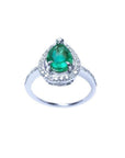 A teardrop natural emerald encircled in a halo diamond crafted in white gold topside view.