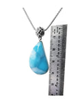 Vivid blue and white teardrop larimar pendant on a sterling silver necklace, next to a ruler.