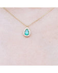 Pear-shaped natural emerald necklace with diamond halo on a 14K yellow gold chain.