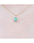 Pear-shaped natural emerald necklace with diamond halo on a 14K yellow gold chain.