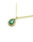 Pear-shaped natural emerald necklace with diamond halo in 14K yellow gold.