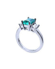 18K white gold three-stone ring with a rectangular emerald and two baguette diamonds.