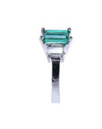 Emerald cut three stone emerald ring with baguette diamonds in 18K white gold.