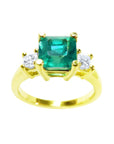 This Emerald-cut three stone emerald ring is showing the top square emerald and side diamonds profile.