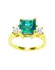 This Emerald-cut three stone emerald ring is showing the top square emerald and side diamonds profile.