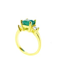 18K yellow gold three-stone ring with a square emerald and princess-cut side diamonds.