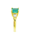 Gold ring with a Colombian emerald and diamond on a side profile display.