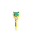 18K yellow gold three-stone ring with a square emerald and princess-cut side diamonds.