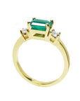 A detailed view of an emerald ring highlighting the top, side gallery, and band.