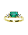 This three stone natural colombian emerald ring displays the main stone with side natural diamonds.