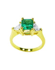 1.27 ct natural Colombian emerald three-stone ring with trillion diamonds in 18K yellow gold.