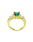 14K yellow gold three-stone ring with a vibrant emerald and two pear-shaped diamonds.