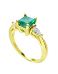 The half side profile of a yellow gold emerald and side diamond ring.
