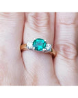 1.12 ct. round cut three stone emerald and diamond ring in 14k white and yellow gold.
