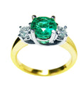 This 14k gold round emerald and side diamonds ring is on a top and lateral profile display.