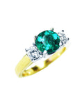 A three stone emerald and side diamond ring on a top and side view.
