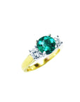 A three stone emerald and side diamond ring on a top and side view.