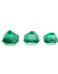 Three emerald-cut natural Colombian emeralds, a matched set for jewelry, on a white background.