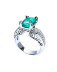 Anillo de oro blanco 18K con esmeralda colombiana rectangular verde profundo y diamantes, estilo antiguo.