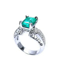 Anillo de oro blanco 18K con esmeralda colombiana rectangular verde profundo y diamantes, estilo antiguo.