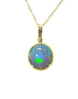 Opal pendant necklace on a gold chain on topside position against a white background