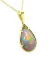 Pear-shaped Ethiopian Welo opal pendant with red-orange fire and rainbow colors, prong set in 14K yellow gold.