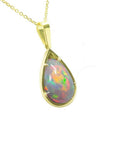 Pear-shaped Ethiopian Welo opal pendant with red-orange fire and rainbow colors, prong set in 14K yellow gold.