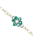 Emerald cluster bracelet with center diamond, crafted in 14k white and yellow gold on a topside view.