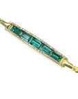 Gold bracelet with five natural colombian emeralds and diamonds on a topside view.