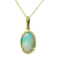 Oval Ethiopian opal pendant with bluish-green hues, prong-set in 14K yellow gold.