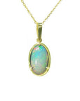 Oval Ethiopian opal pendant with bluish-green hues, prong-set in 14K yellow gold.