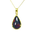 Pear-shaped Welo black opal pendant with red-orange fire and bluish-green flashes, set in 14K yellow gold.