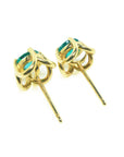 A pair of 14k gold tulip emerald stud earrings, underside profile view.
