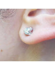 14K white gold tulip natural diamond stud earring with round-cut center and accent diamond petals.