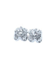 A pair of white gold diamond stud earrings with a round cut and tulip prong set style, featuring accent diamond petals.